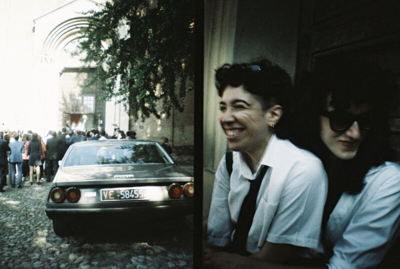 On the left, a vintage car with a "VE" license plate is parked on a cobblestone street near a crowd by a church. On the right, two people with short dark hair and sunglasses are sitting and smiling.