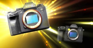 Two digital cameras are floating against a dynamic background of yellow and orange light streaks. The larger camera is positioned to the left, while a smaller version is on the right. Both cameras have visible lens mounts.