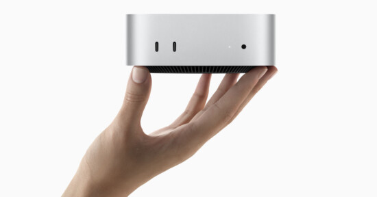 A hand holding a small, sleek, silver electronic device with ports on the front. The device appears compact and minimalist, suggesting a modern and portable design suitable for technology use.