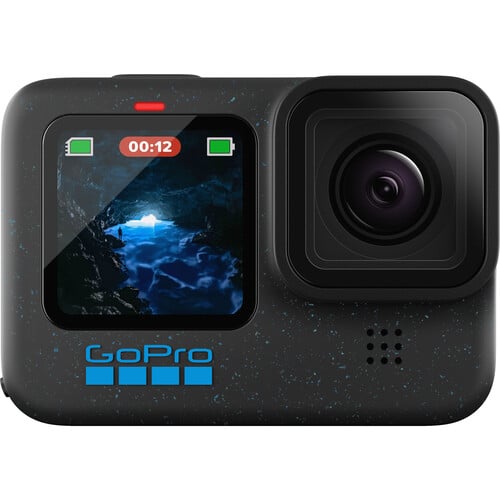 A GoPro camera with a small digital screen on the front displaying an image of a cave with water and light. The device is black with a blue GoPro logo beneath the screen. There are icons showing a battery and recording status.