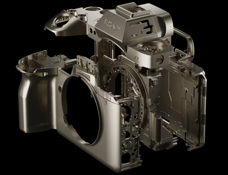 Exploded view of a camera body showcasing its metal frame and interior components against a black background. The camera is partially assembled, with sections open to reveal internal structures and mechanics.