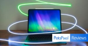 A sleek tablet with a keyboard attachment displays a vibrant, colorful aurora on the screen. Light trails surround the device, adding a dynamic effect. The Petapixel logo and the word "Reviews" are visible in the bottom right corner.