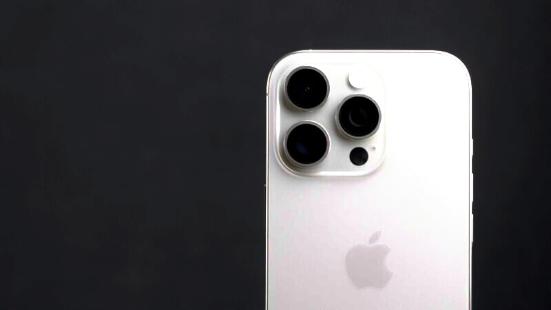 An image of the upper back portion of a white iPhone against a dark background. The focus is on the three camera lenses and the Apple logo.