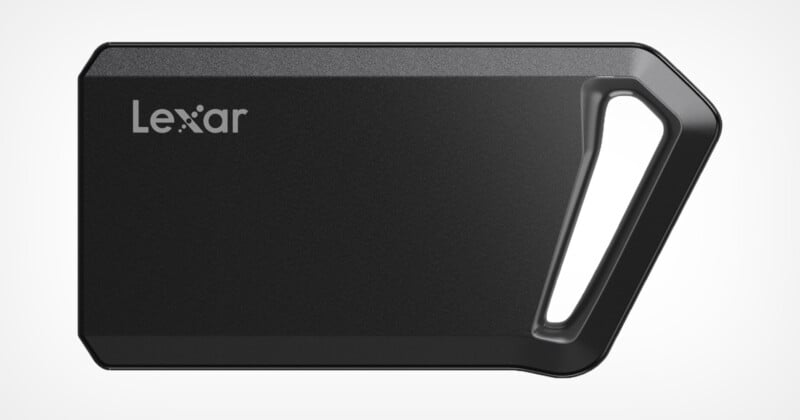 A black Lexar portable SSD with a sleek design and an angled, integrated keyring hole on one side. The brand name "Lexar" is printed in the top left corner. The SSD has a modern, compact appearance.