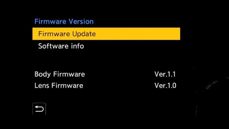 A digital menu displaying firmware options. The highlighted option is "Firmware Update." Below, it shows "Body Firmware Ver.1.1" and "Lens Firmware Ver.1.0" against a black background.