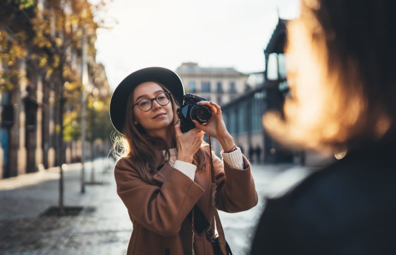 A woman photographer shooting a portrait in a street