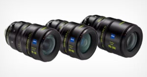 Three Zeiss camera lenses are displayed in a row, varying in size. Each lens features green and white markings, indicating focal lengths of 15-30mm, 28-80mm, and 70-200mm. The lenses have a sleek design with a professional appearance.